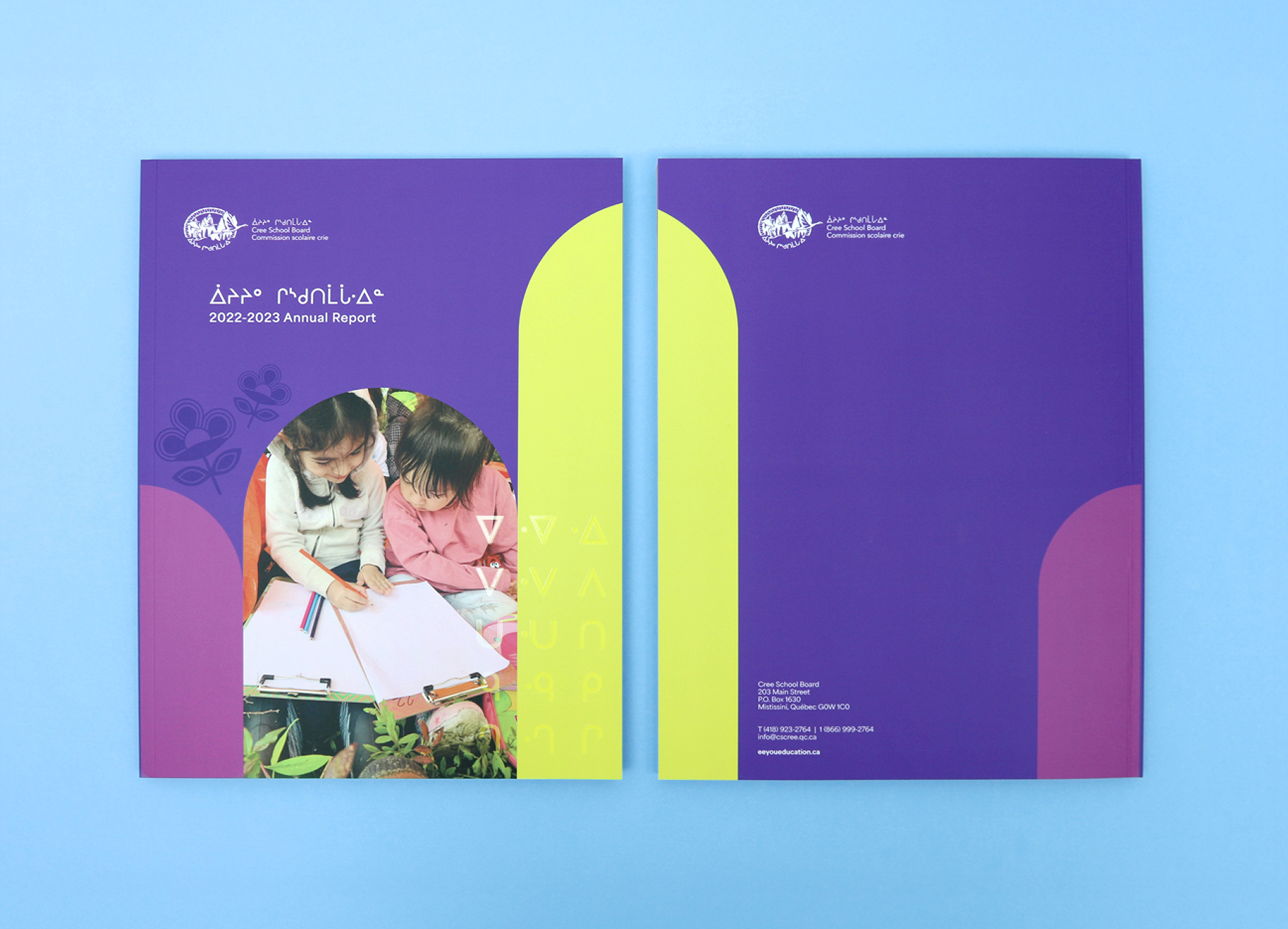 CSB_202223_Body-1 Two annual report booklets with purple, yellow, and pink geometric covers. The front cover features two children writing in notebooks, with text and logos in English and another language, on a light blue background.