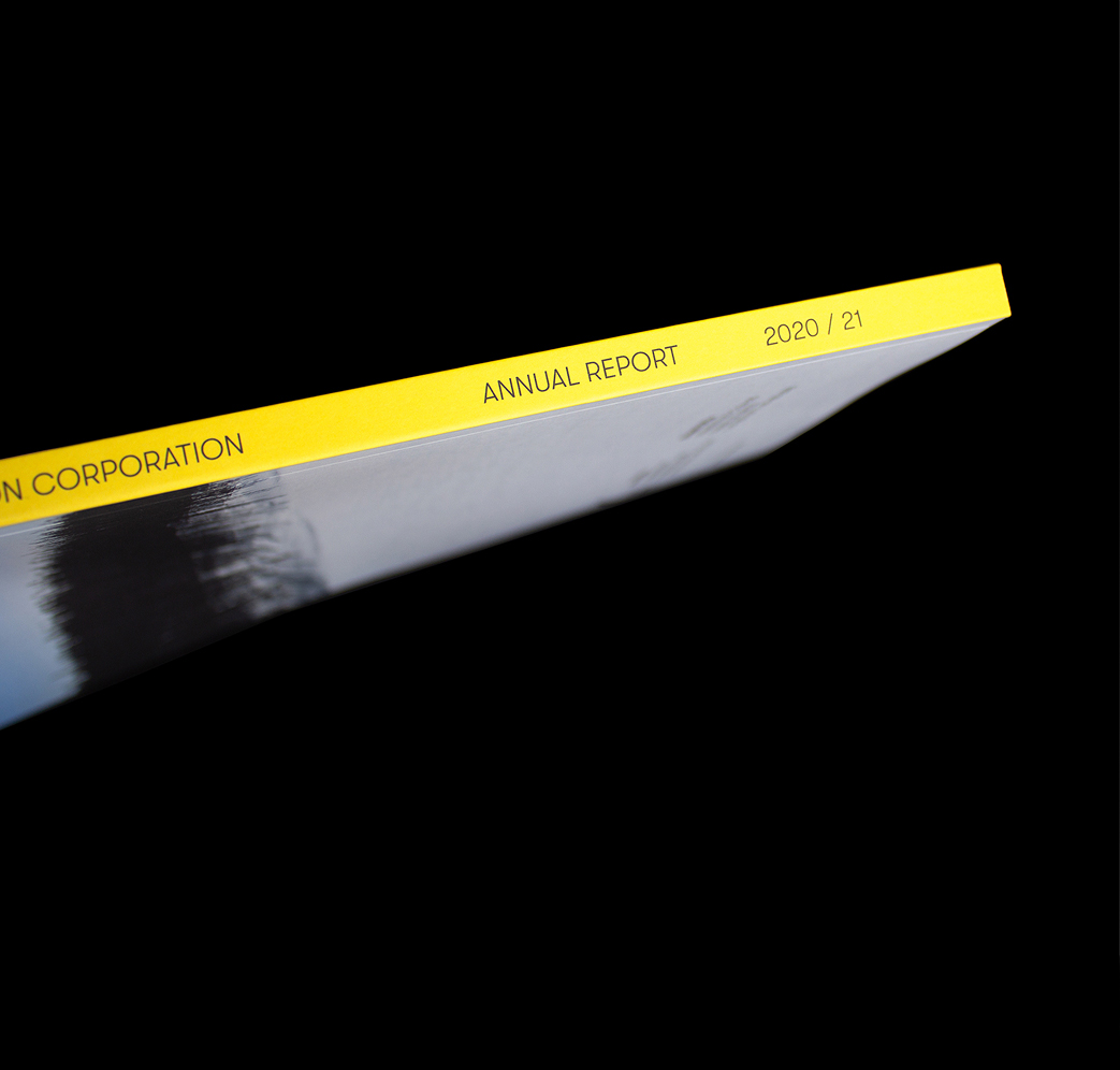 Niskamoon_202021-2 Close-up of the spine of a book with a yellow edge, labeled “ANNUAL REPORT 2020 / 21” on a black background. The partial company name is visible, ending with “N CORPORATION.”.