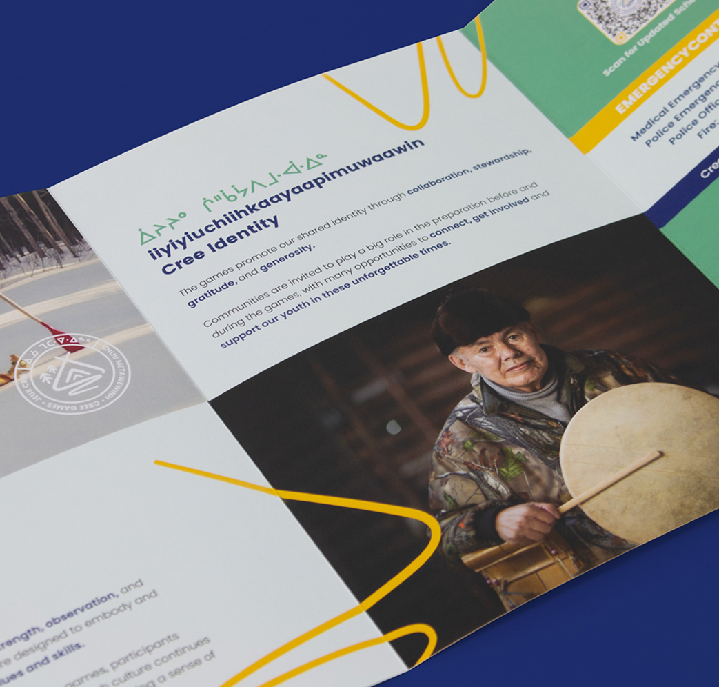 A brochure page features text in English and an Indigenous syllabic script, along with a photo of an elderly person wearing a beret and holding a hand drum. The background is blue with yellow design elements.