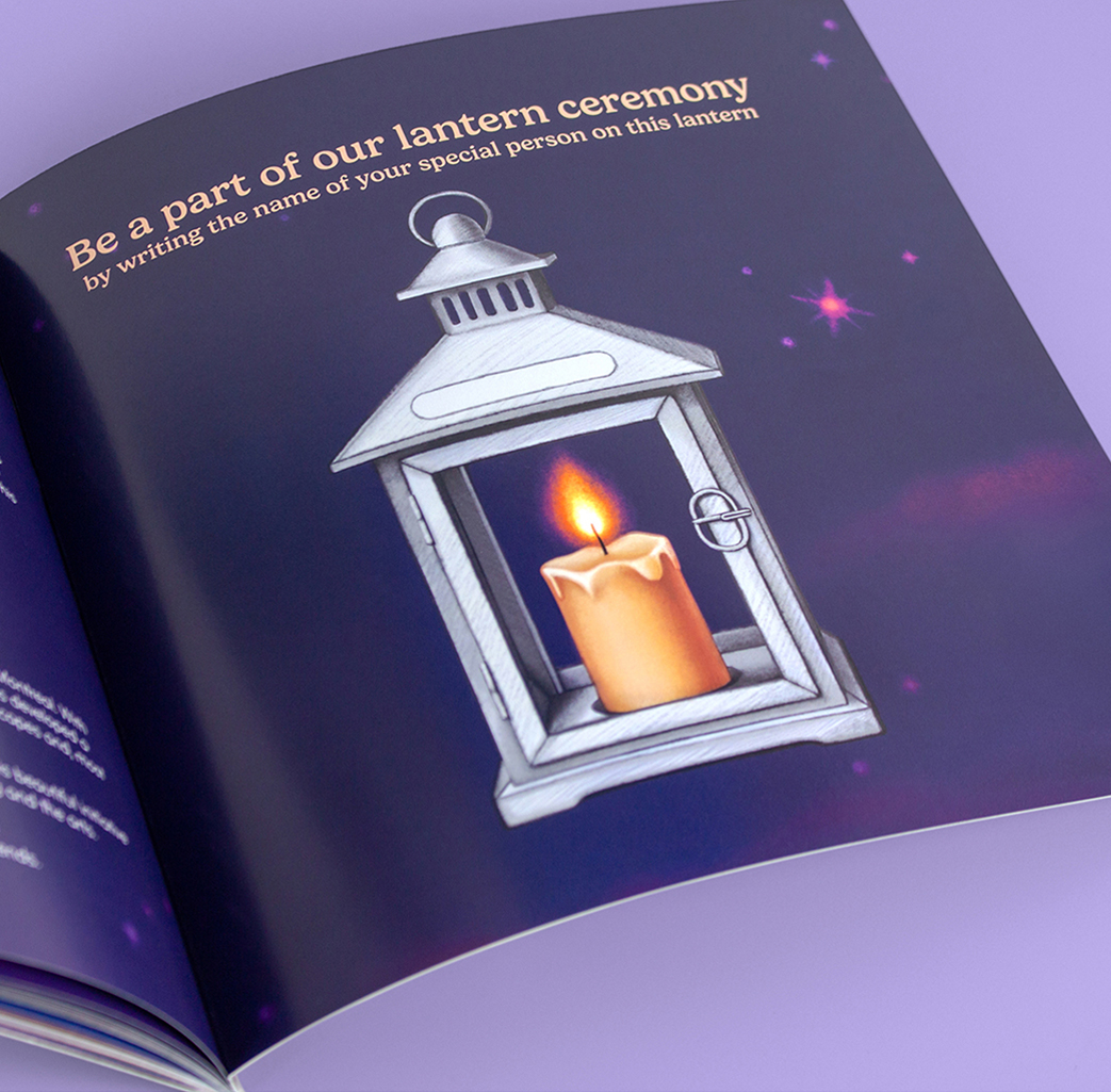 An open booklet showing an illustration of a white lantern with a lit candle inside, set against a dark, starry background. The page reads,