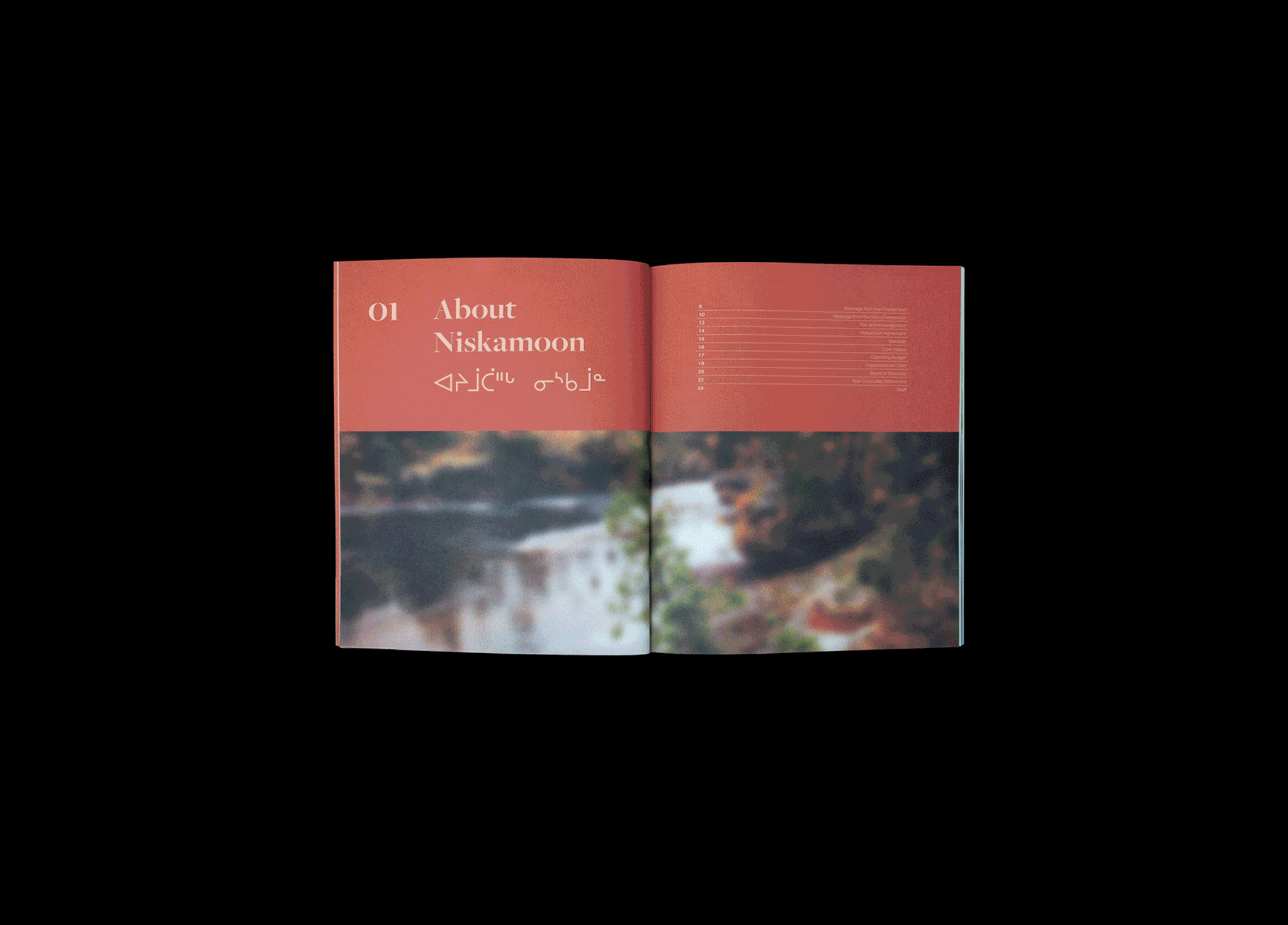 An open booklet with a red header reading "01 About Niskamoon" and text in an Indigenous syllabic script, above a blurred nature scene across both pages.